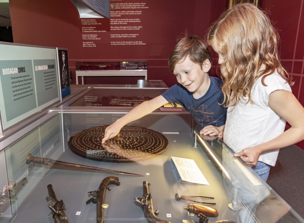 Interior image of armadale castle museum with children looking at objects