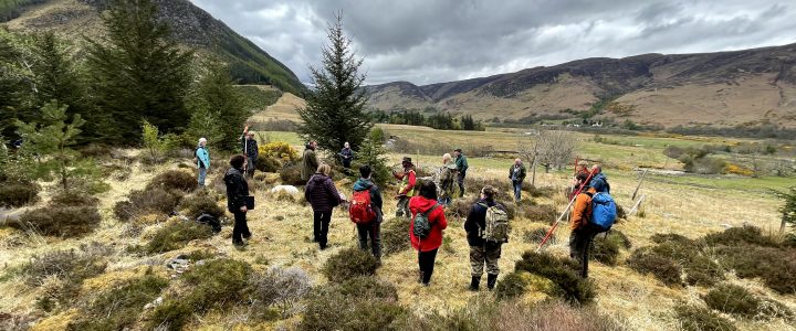 view of glen with community members standing in circle surveying site