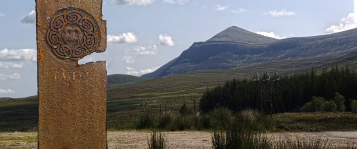 Brand-new podcast ‘Highlands Reimagined’ asks why young people leave northwest Sutherland picture of a tall, narrow standing stone with circular image and the word 'failte' written on it. In the background is a a pointed mountain and blue sky with white fluffy clouds