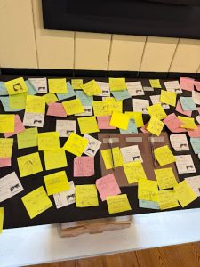 Display board covered with colourful sticky notes containing visitor comments, ideas and drawings contributed by museum visitors.