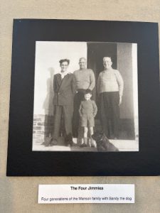 Historic black and white family photograph titled "The Four Jimmies", showing four generations of the Manson family with their dog, Sandy.