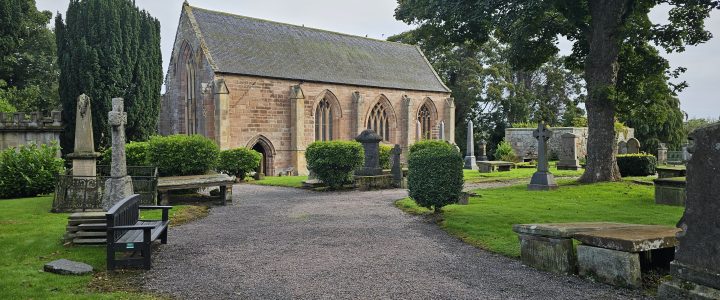 Meet the Team: Emma Hits the Road with Pathways to the Future A stone church with Gothic arched windows surrounded by a historic graveyard, mature trees, gravestones and green lawns.